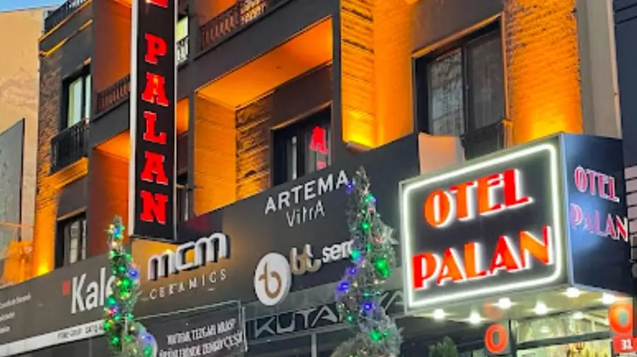 Otel Palan'ın ışıklı tabelası ve girişi